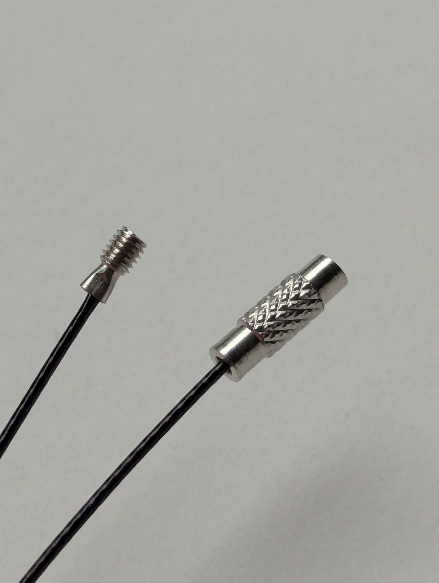 A black stainless steel necklace with a silver screw clasp displayed on a neutral background