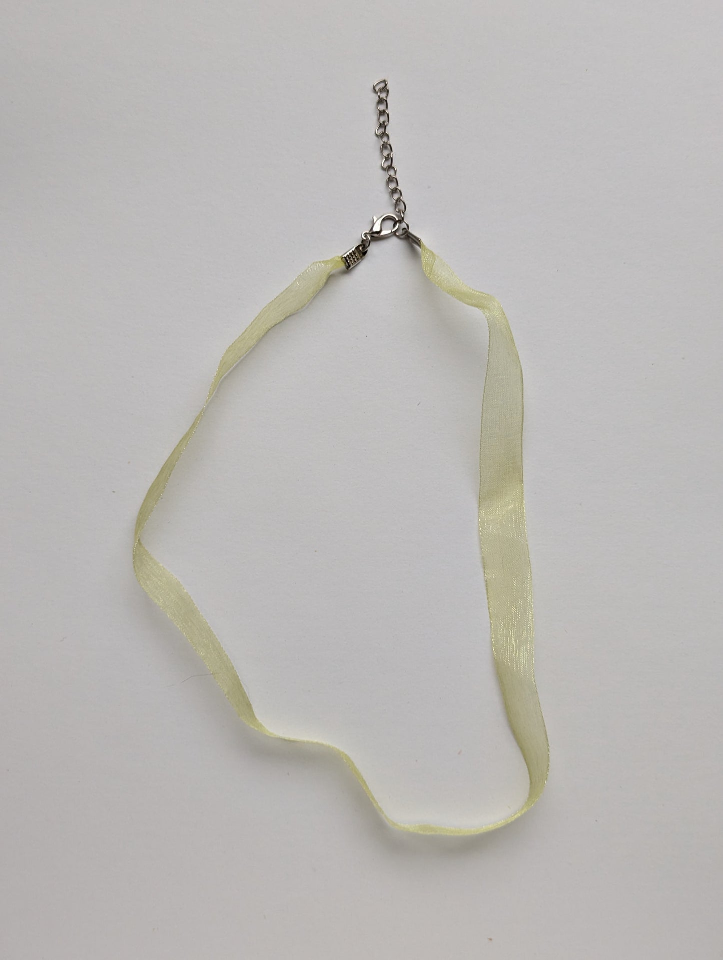 yellow ribbon necklace on a neutral background