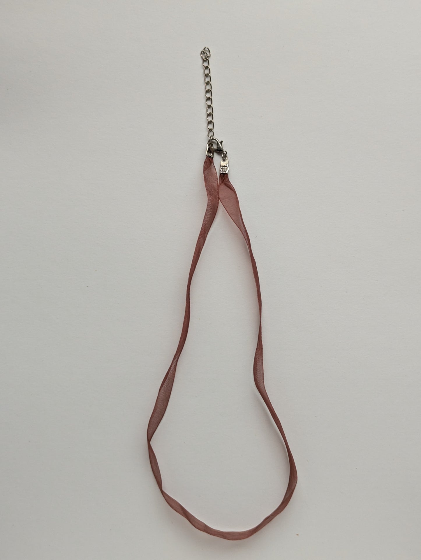 rust colored ribbon necklace with a silver clasp and chain