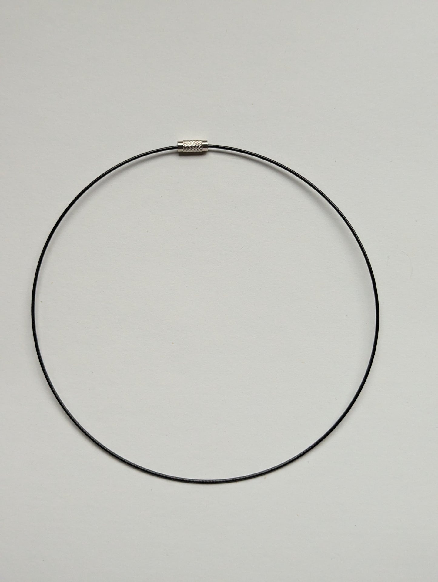 black stainless steel necklace on a neutral background