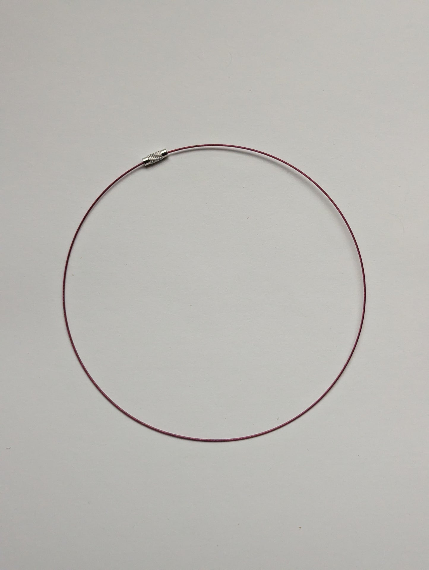 brown stainless steel necklace on a neutral background