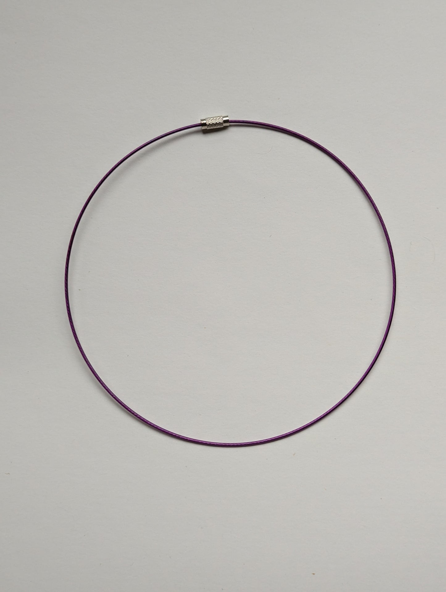 purple stainless steel necklace on a neutral background