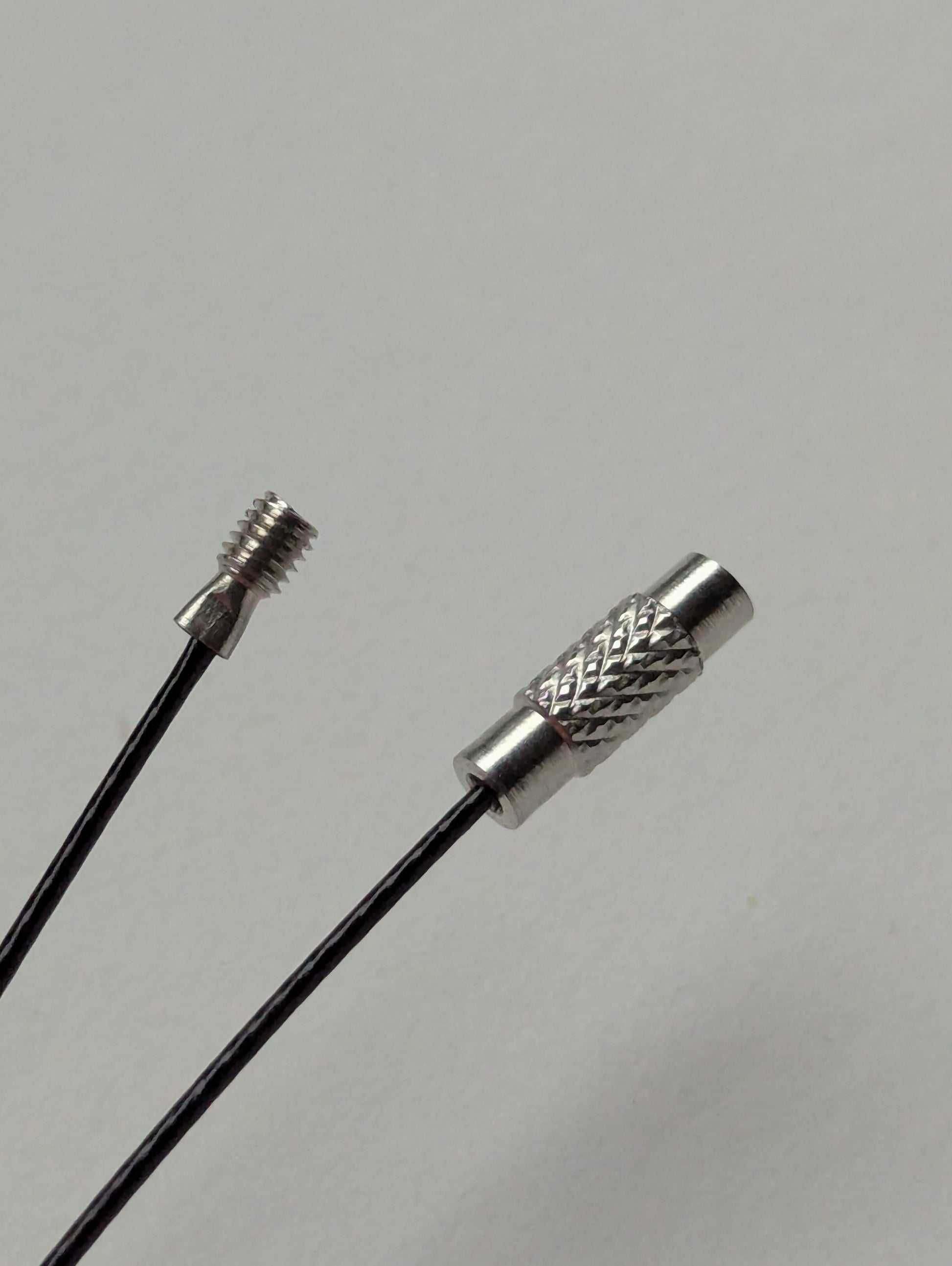 A black stainless steel necklace with a silver screw clasp displayed on a neutral background