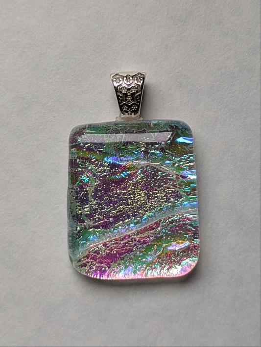 A colorful clear fused glass pendant with a metallic clasp, displaying an eye-catching design.