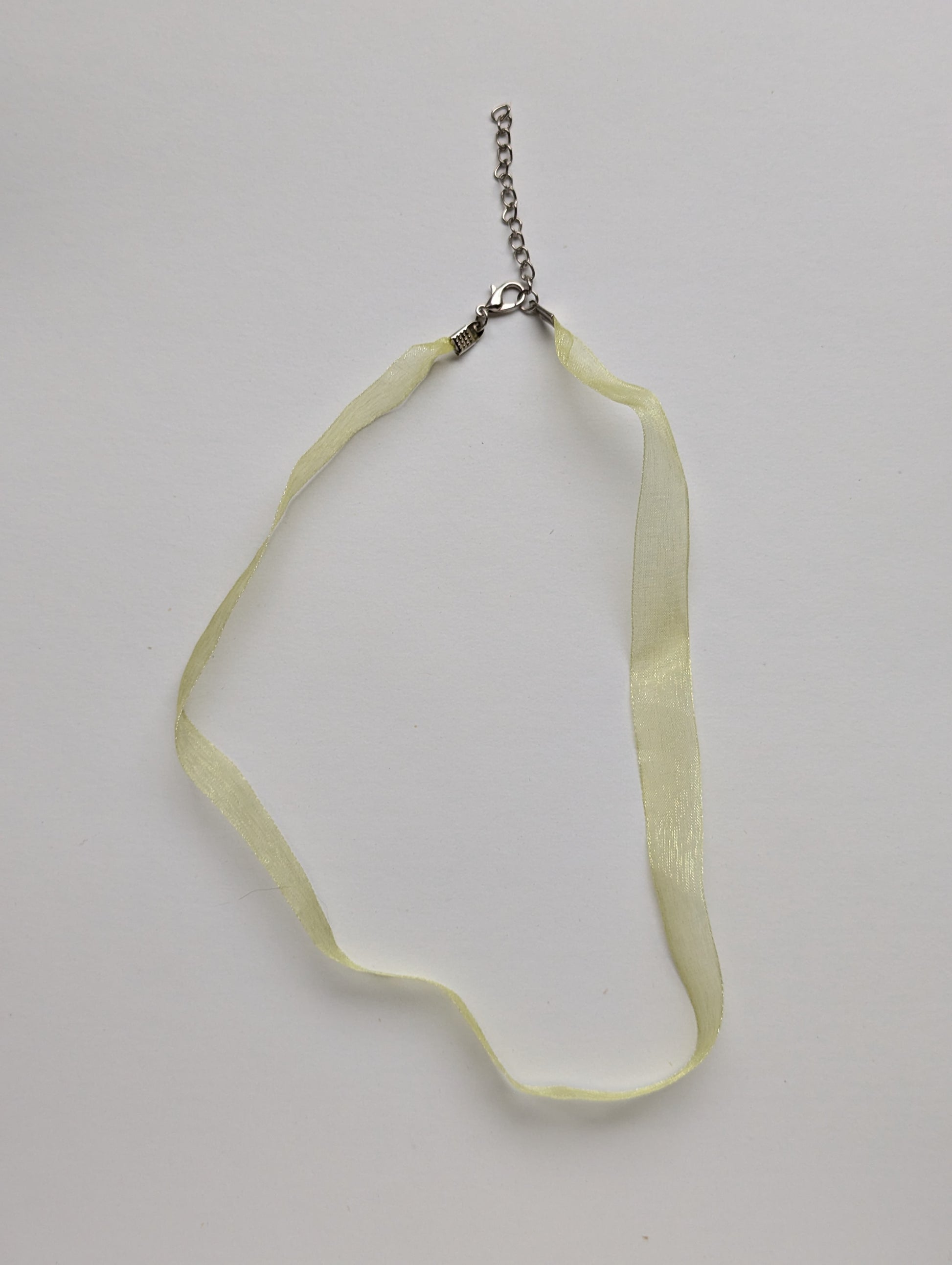 yellow ribbon necklace on a neutral background