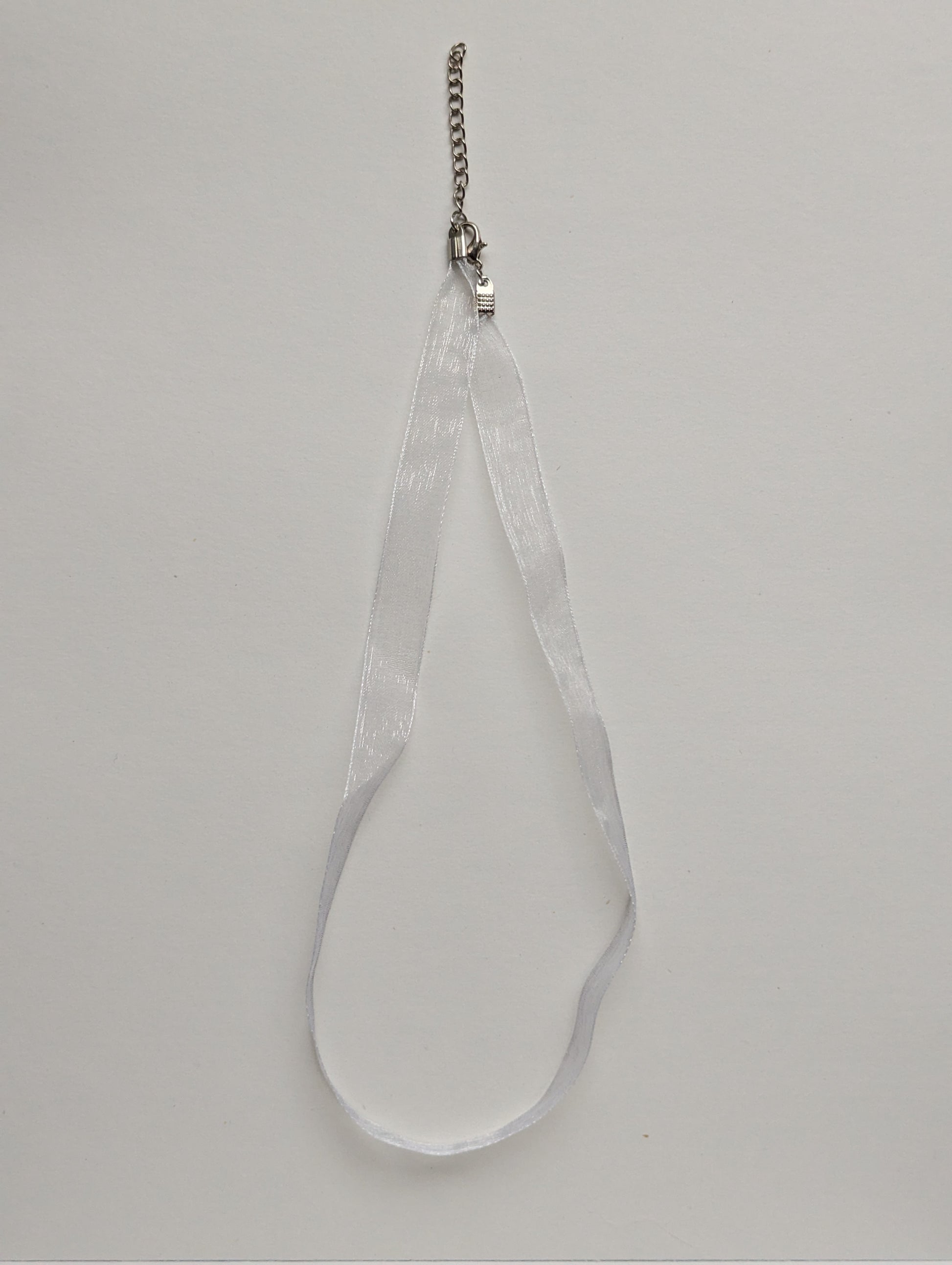 white ribbon necklace with silver metallic clasp and adjustable chain