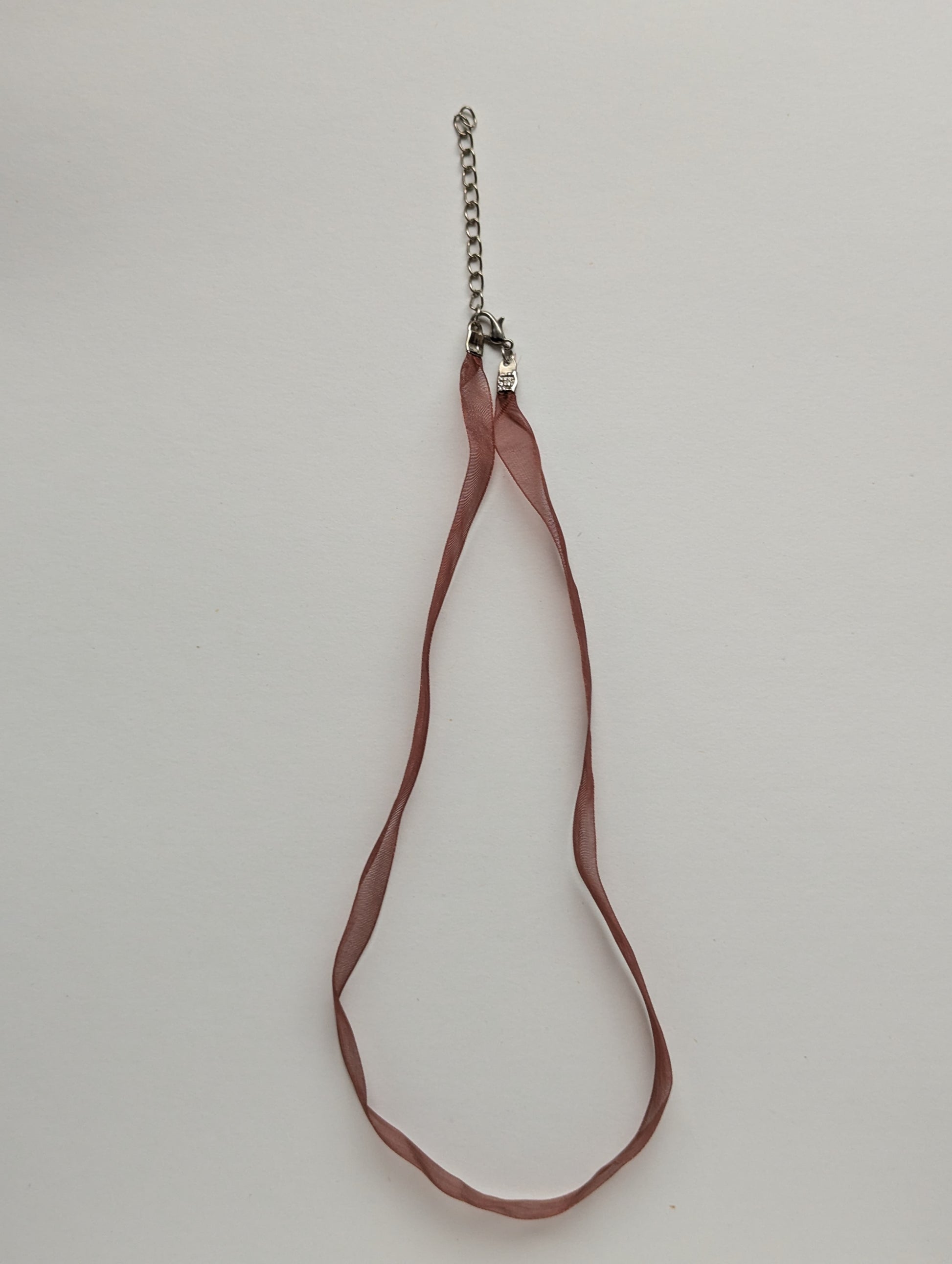 rust colored ribbon necklace with a silver clasp and chain
