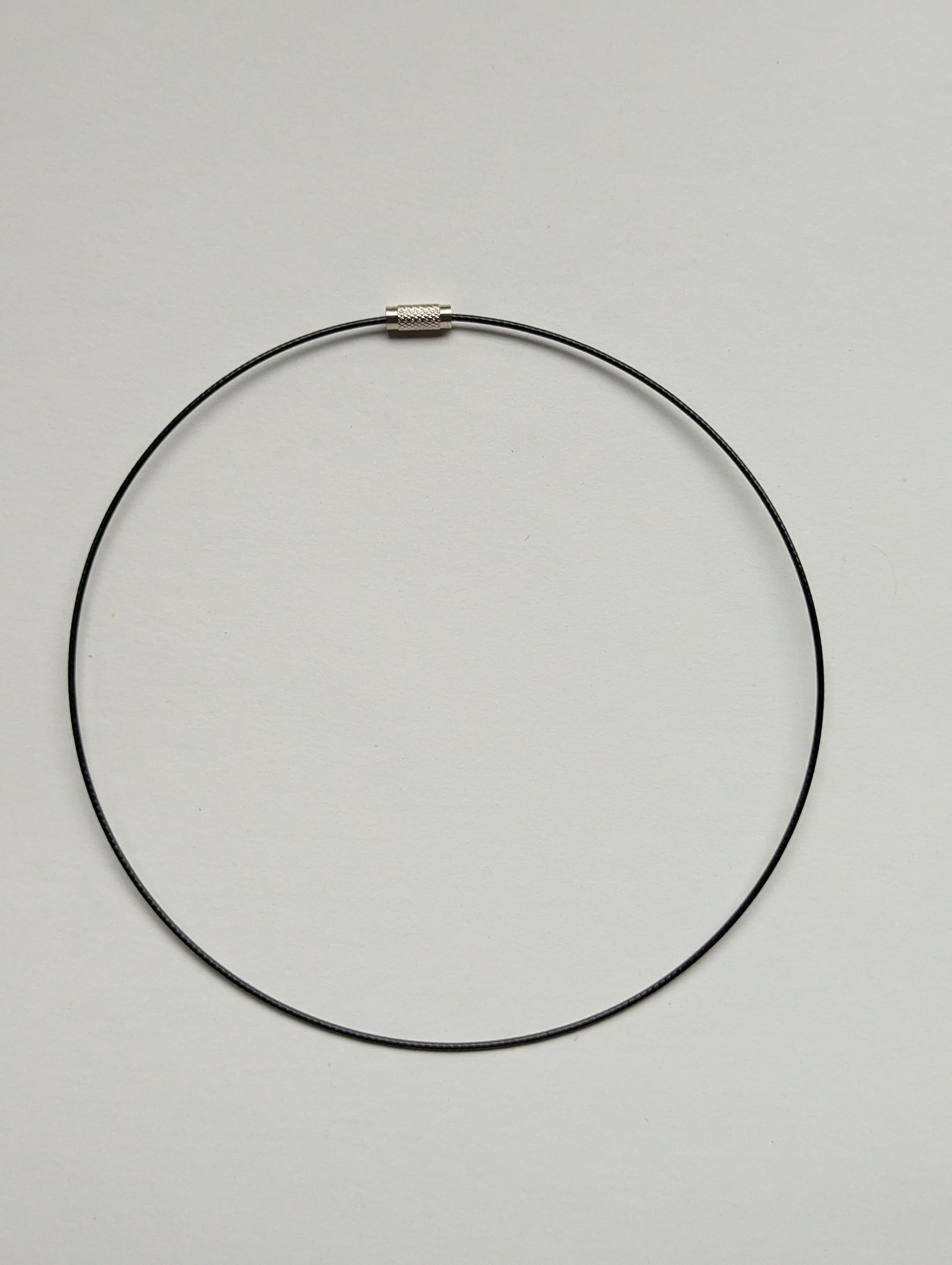 black stainless steel necklace on a neutral background